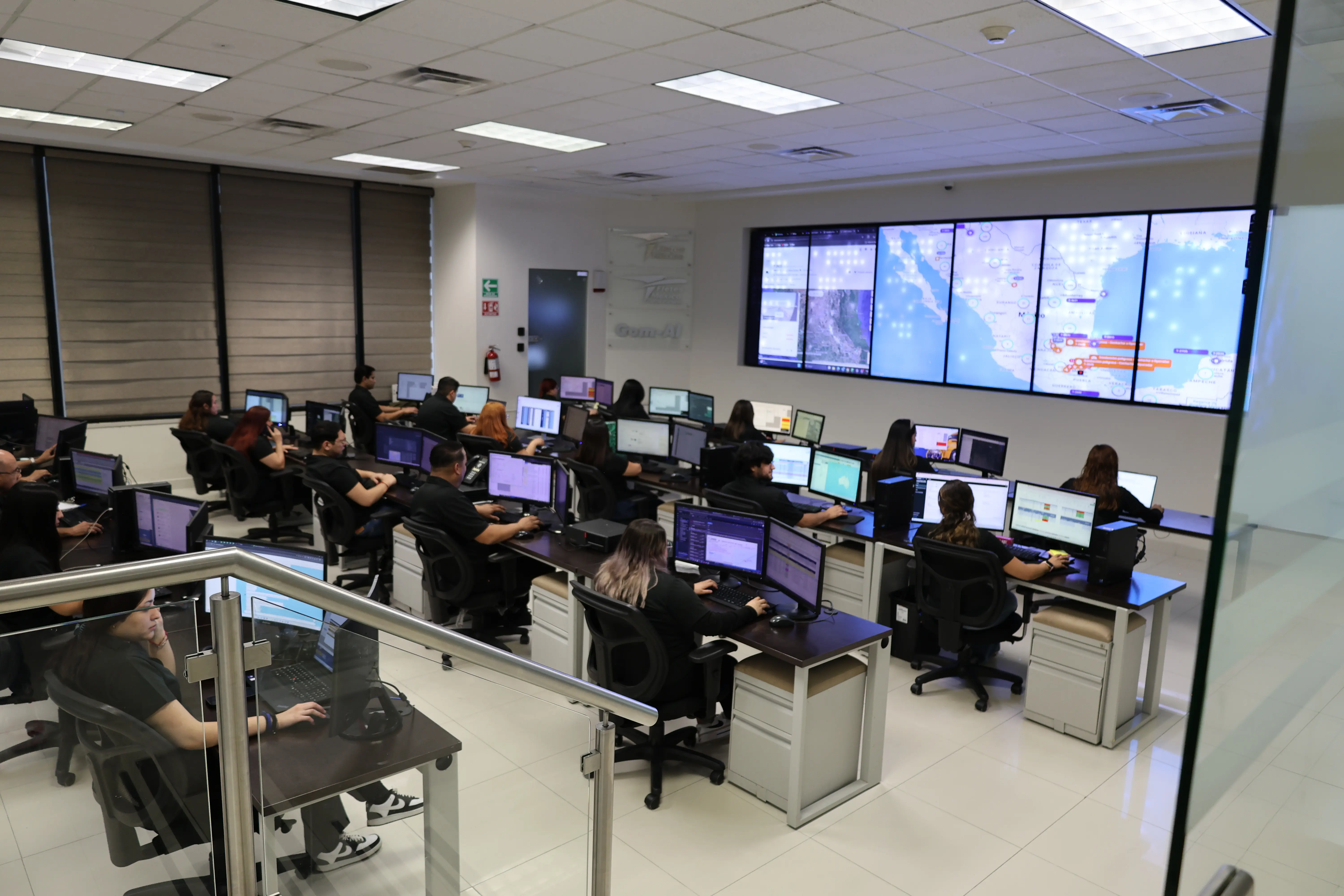 Centro de monitoreo con operadores y pantallas de rastreo